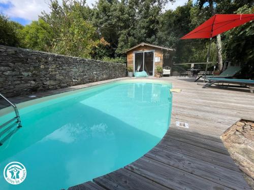 - une piscine avec un parasol et une terrasse en bois dans l'établissement Maison rénovée avec jardin, piscine chauffée et wifi à Mareuil-sur-Lay - FR-1-426-537, à Mareuil-sur-Lay
