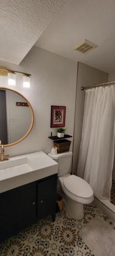 a bathroom with a toilet and a sink and a mirror at Casa Sunrise, Large Home, Minutes from Airport, YRMC, Mexico Borders in Yuma