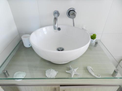 ein Badezimmer mit einem Waschbecken und Seestern auf einer Glasscheibe in der Unterkunft Oceanview Apartment 3 bedrooms in Coveñas