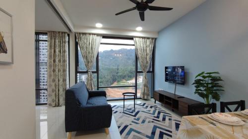 un salon avec une chaise bleue et une grande fenêtre dans l'établissement FHAZ KLE- 2bdroom at KL East Mall ! Gombak, à Kuala Lumpur