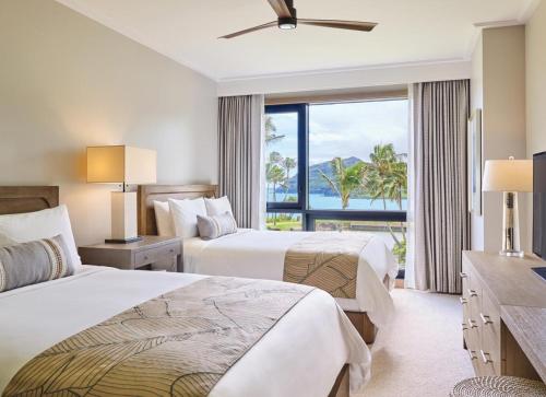 two beds in a hotel room with a view of the ocean at Timbers Kaua'i in Lihue