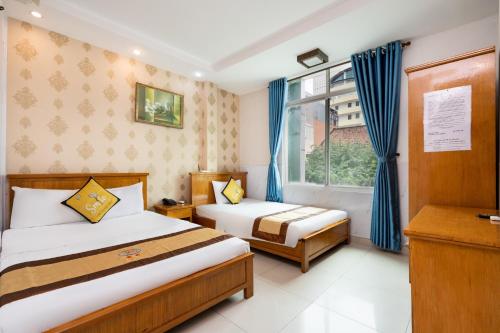 a bedroom with two beds and a window at Janus Hotel 168 in Ho Chi Minh City