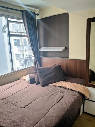 Tempat tidur dalam kamar di The Jarrdin Apartement by Apato
