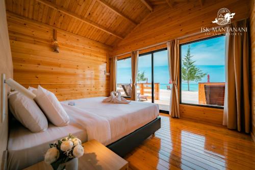 a bedroom with a bed and a large window at JSK Mantanani Island Resorts in Mantanani Island 