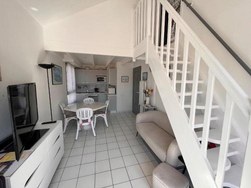 un salon avec un escalier et une cuisine dans l'établissement Duplex 4 pers, à 150m de la plage avec garage privé - FR-1-197-574, à Les Sables-dʼOlonne