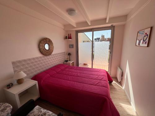 une chambre avec un lit rouge et une grande fenêtre dans l'établissement Duplex 4 pers, à 150m de la plage avec garage privé - FR-1-197-574, à Les Sables-dʼOlonne