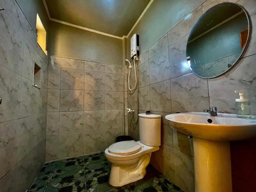 a bathroom with a sink and a toilet and a mirror at GOLDEN SUNSET INN in Siquijor