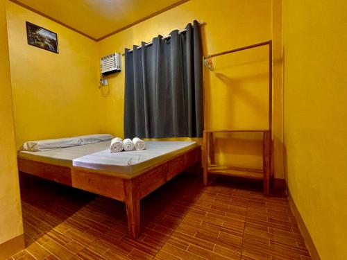 a bedroom with a bed in a yellow room at GOLDEN SUNSET INN in Siquijor