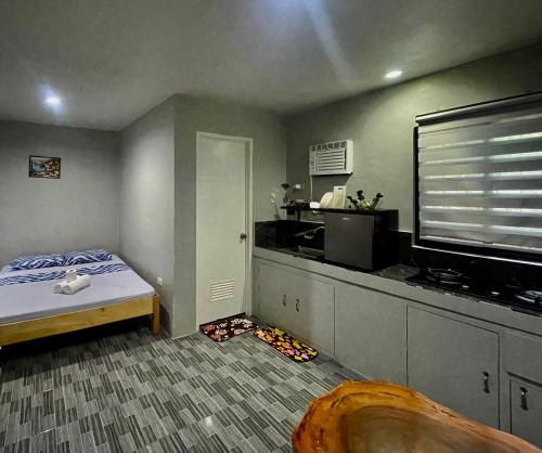 um pequeno quarto com uma cama e uma cozinha em GOLDEN SUNSET INN em Siquijor