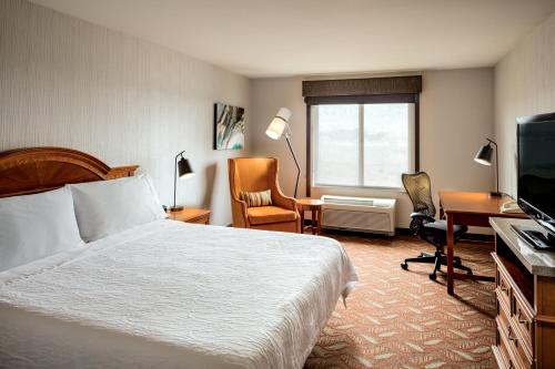 een hotelkamer met een bed, een bureau en een televisie bij Hilton Garden Inn Tri-Cities/Kennewick in Kennewick