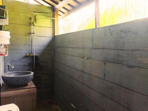 a bathroom with a stone sink and a window at Jungle Haven Bali - Eco Lodge in Meliling