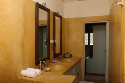 a bathroom with two sinks and two mirrors at Khalid's Guest House in Galle