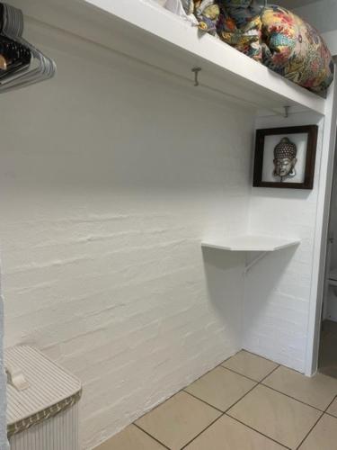 a bathroom with a white wall with a picture on it at Myuna Holiday Apartments in Noosa Heads