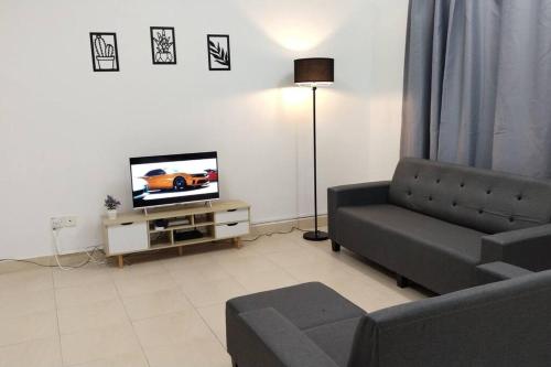 uma sala de estar com um sofá e uma televisão em 1181 GCH S2 # U Homestay em Seremban