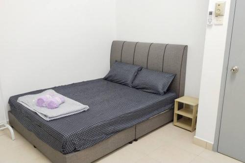 uma cama com uma cabeceira cinzenta e duas almofadas em 1181 GCH S2 # U Homestay em Seremban