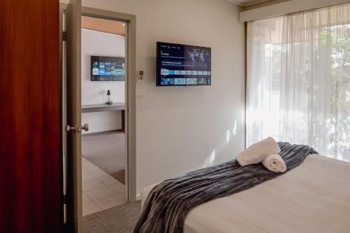 a bedroom with a bed and a sliding glass door at Mitchell On Main in Bairnsdale