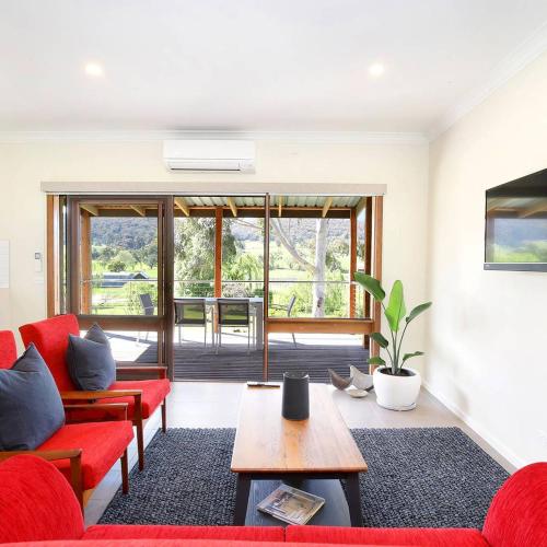 a living room with a red couch and a table at Belaradah on Stefani Estate Winery in Healesville