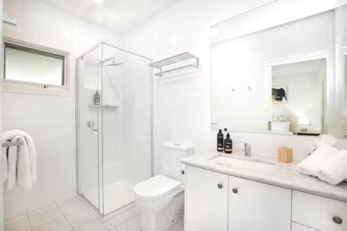 a white bathroom with a shower and a toilet at Belaradah on Stefani Estate Winery in Healesville