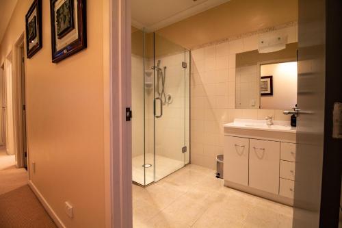 uma casa de banho com um chuveiro e um lavatório. em Large luxury apartment located right in town em Taupo
