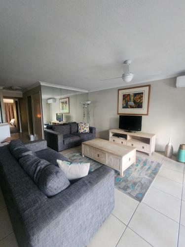 a living room with a couch and a tv at Bayview Bay Apartments and Marina in Gold Coast