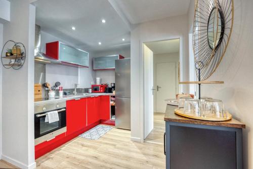 une cuisine avec des placards rouges et un comptoir rouge dans l'établissement Libertad - Verdun, à Grenoble