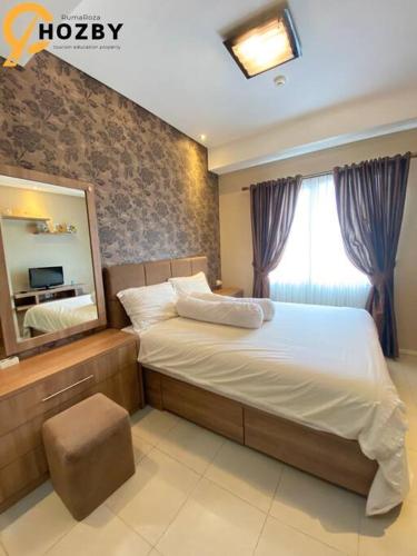 - une chambre avec un grand lit et un miroir dans l'établissement Thamrin City Serviced Apartment Full Facilities B2CT1, à Jakarta