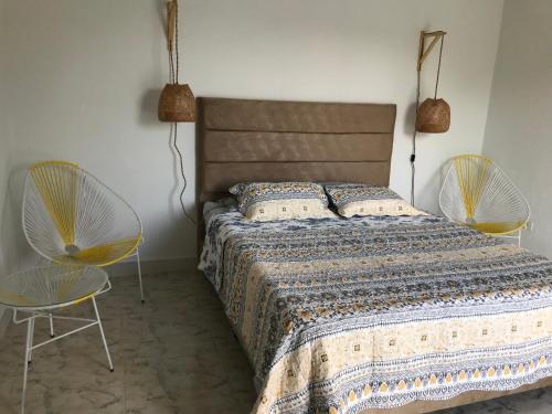 1 Schlafzimmer mit einem Bett und 2 Stühlen in der Unterkunft Casa Hotel el Encanto de Carmen 