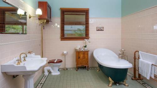 a bathroom with two sinks and a tub and a toilet at Reign Manor in Worragee