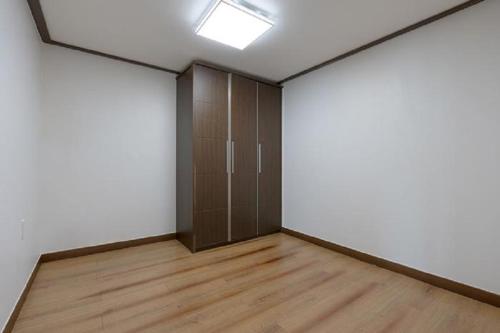 an empty room with a door and a wooden floor at Namhae Season Hotel in Namhae