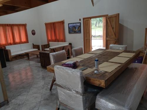 una sala da pranzo con tavolo e sedie in legno di Preciosa cabaña rústica 