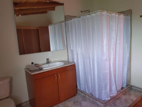 a bathroom with a sink and a shower curtain at Preciosa cabaña rústica 