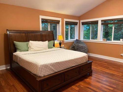 1 dormitorio con 1 cama en una habitación con ventanas en Serene Oasis Getaway with Sauna and a swim spa. en Portland