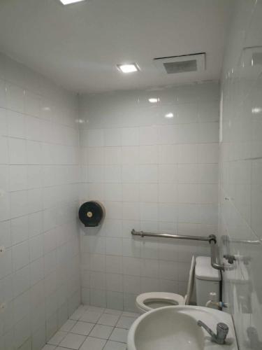 a white bathroom with a toilet and a sink at WJV INN BASAK MANDAUE BRANCH in Mandaue City