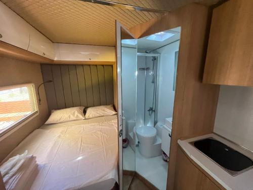 a small room with a bed and a shower at Premium Caravan in Sapanca