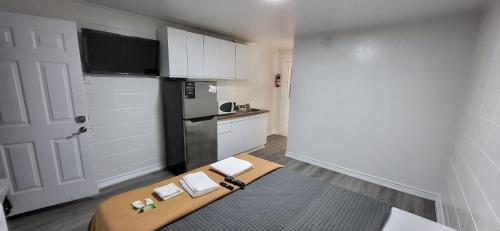a small kitchen with a table and a refrigerator at Happyland Inn in Orillia