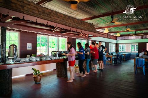 a group of people standing around a bar in a restaurant at JSK Mantanani Island Resorts in Mantanani Island 