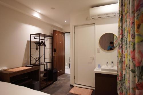 a bathroom with a sink and a mirror at MARUKOU HOTEL in Tokyo