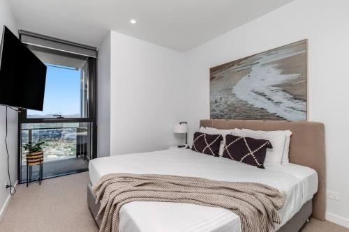 a bedroom with a large bed and a flat screen tv at Golden Horizons - Resort Living in the Clouds in Gold Coast