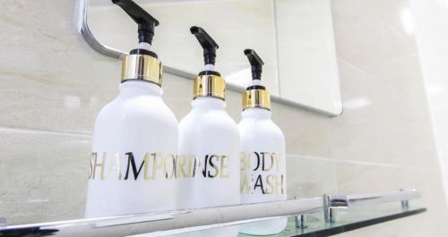 dos botellas blancas con tapas de oro colgando en un estante en Itaewon A One Hotel en Seúl