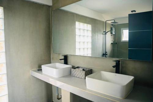 ein Badezimmer mit 2 Waschbecken und einem Spiegel in der Unterkunft Fight Club Philippines Fitness Resort in Bacungan