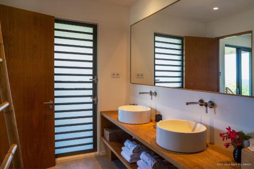 La salle de bains est pourvue de 2 lavabos et d'un miroir. dans l'établissement Villa Coco Rock, à Saint Barthelemy
