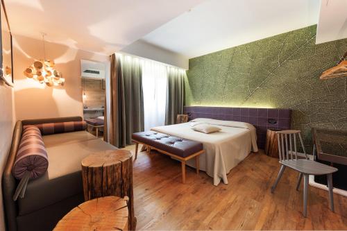 a hotel room with a bed and a couch at Hotel La Pergola in Grezzana