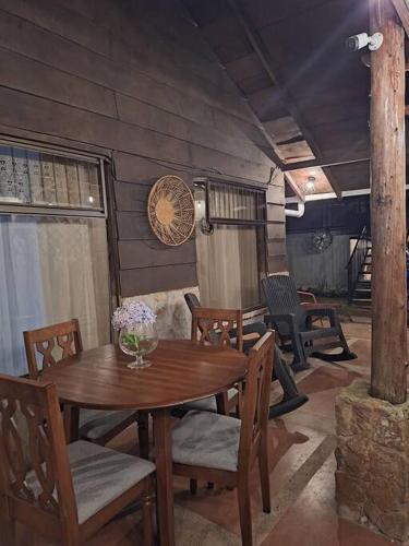 a wooden table and chairs in a room with a table and chairs at Preciosa cabaña en Fraijanes in Fraijanes
