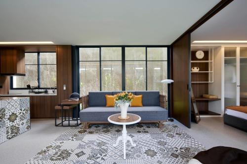 a living room with a blue couch and a table at Adamare Villa Umalas in Kerobokan