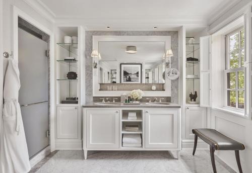 W białej łazience znajduje się umywalka i lustro. w obiekcie Rosewood Washington DC w Waszyngtonie