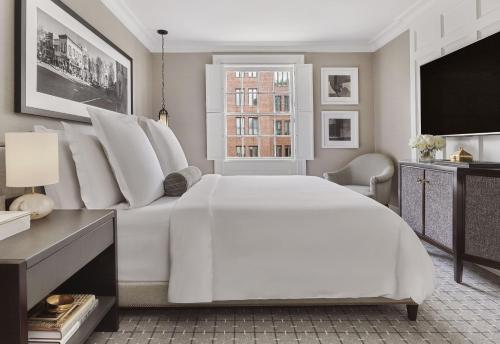 a white bedroom with a large white bed and a window at Rosewood Washington DC in Washington, D.C.