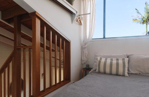 a bedroom with a bed and a stair case at Pippi Beach Loft in Yamba