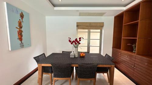 uma sala de jantar com uma mesa com cadeiras e flores em The Residence Resort & Spa Retreat em Praia de Bang Tao