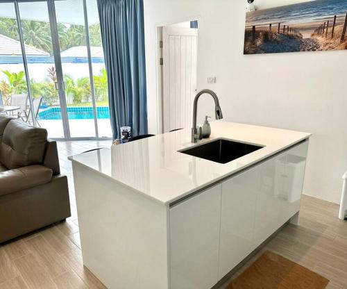 una cucina bianca con lavandino e un soggiorno di 2 Bedroom Paradise Island Villa a Lipa Noi