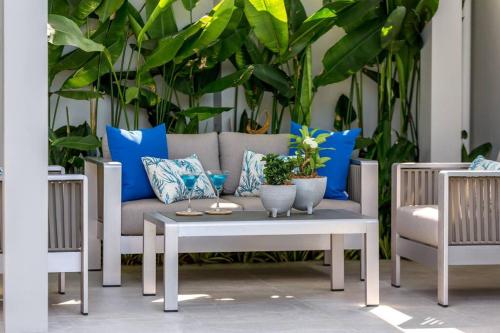 a patio with a couch and a table and chairs at Big & Stylish 5 Bed 4 Bath Private Garden Pool Villa at Thongson Bay Beach in Koh Samui 